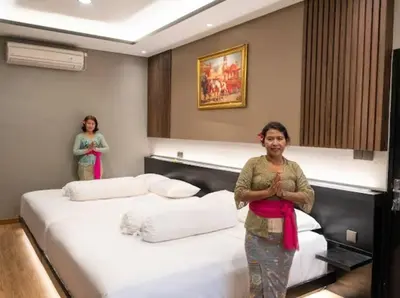 two women standing in a room with two beds at Modern Palace in Seminyak - Qmoya Villa in Seminyak
