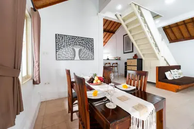 a dining room and living room with a table and chairs at Villa Putri Mila in Seminyak