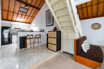 a kitchen with a staircase and a table and chairs at Villa Putri Mila in Seminyak