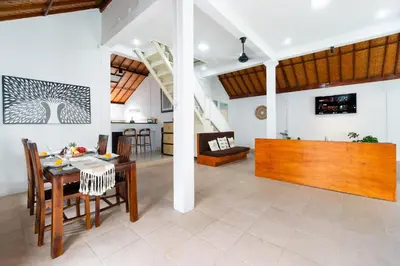 a dining room and living room with a table and chairs at Villa Putri Mila in Seminyak