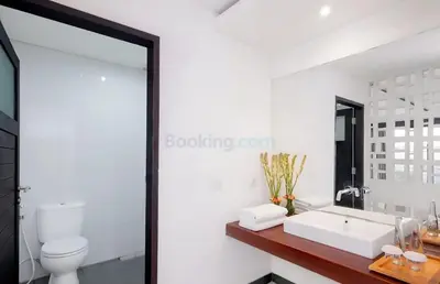 a bathroom with a white sink and a mirror at The Kanjeng Suites Kuta Galeria - Bali in Kuta