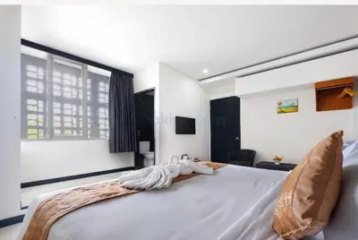 a large white bed with two towels on it at The Kanjeng Suites Kuta Galeria - Bali in Kuta