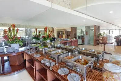a buffet in a restaurant with many trays of food at The Kanjeng Suites Kuta Galeria - Bali in Kuta