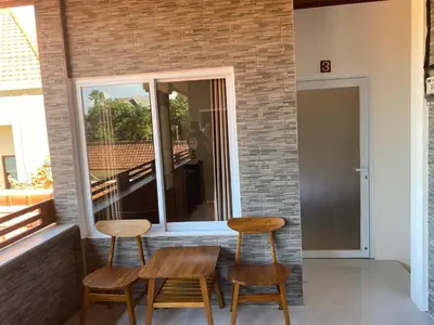two chairs and a table in front of a window at Manis Guest House in Seminyak