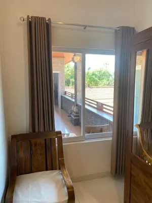 a room with a window with a view of a porch at Manis Guest House in Seminyak
