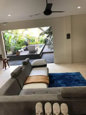 a living room with a couch and a patio at Big 3 bed, to BatuBelig Beach, last min specials in Kerobokan