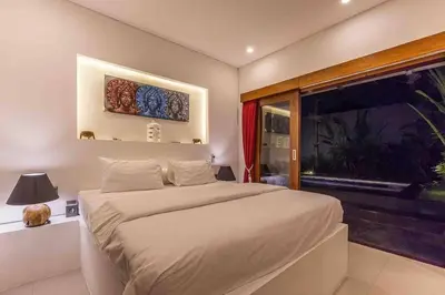 a bedroom with a large bed and a window at Big 3 bed, to BatuBelig Beach, last min specials in Kerobokan