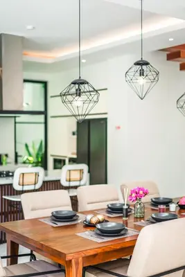 a dining room with a wooden table and chairs at Villa Blue Water by GORO in Seminyak