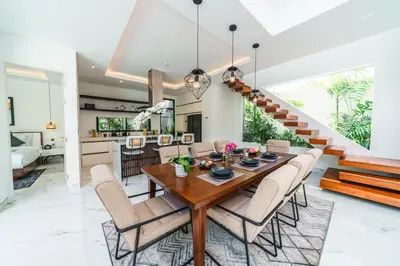 a dining room with a wooden table and chairs at Villa Blue Water by GORO in Seminyak