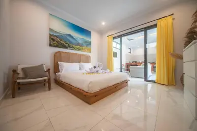 a bedroom with a bed and a chair in it at Villa Semangka, Seminyak Umalas in Kerobokan
