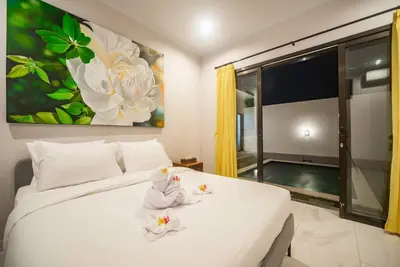 a bedroom with a white bed with towels on it at Villa Semangka, Seminyak Umalas in Kerobokan