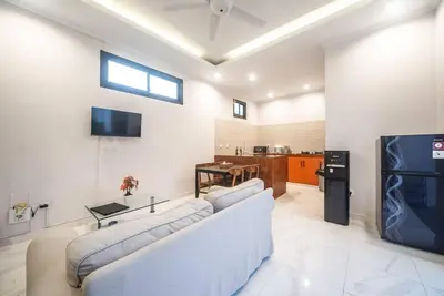a living room with a white couch and a tv at Villa Semangka, Seminyak Umalas in Kerobokan