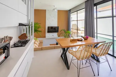 a kitchen and living room with a wooden table and chairs at Letto 1 - Luxurious Villa with Pool in Canggu in Canggu