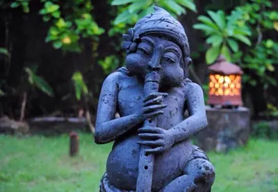 a statue of a boy playing a instrument at Villa Chandra in Seminyak