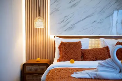 a bedroom with a bed with brown and white pillows at Villa bella wilson II in Seminyak