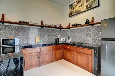a kitchen with wooden cabinets and a black counter top at Villa bella wilson II in Seminyak