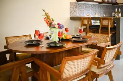 a wooden table with wine glasses and a vase of flowers at Villa bella wilson II in Seminyak
