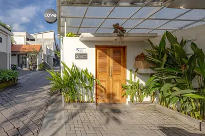 a house with a wooden door on a street at Cove Lotus Lofts Seminyak in Seminyak