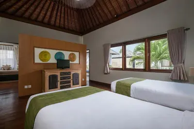 a hotel room with two beds and a television at Classic tropical villa with private pool in Umalas in Dalung