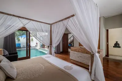 a bedroom with a canopy bed and a swimming pool at Classic tropical villa with private pool in Umalas in Dalung