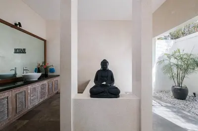 a buddha statue sitting on a table in a room at Classic tropical villa with private pool in Umalas in Dalung
