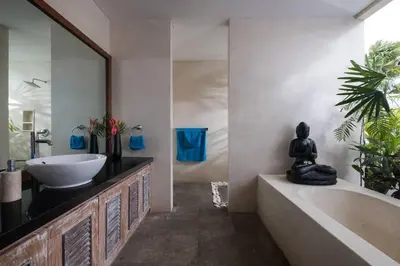 a bathroom with a bath tub and a sink and a mirror at Classic tropical villa with private pool in Umalas in Dalung