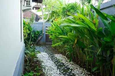 a garden path with plants and gravel at VIlla Dafne in Seminyak