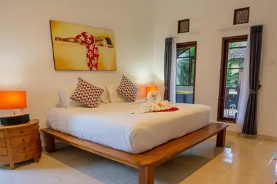 a bedroom with a large white bed and two lamps at VIlla Dafne in Seminyak