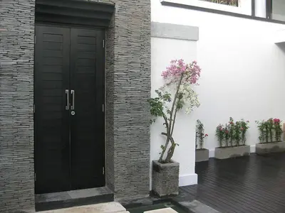 a black door with a tree next to a building at 7to8BR 40 off special Brilliant Location in Seminyak