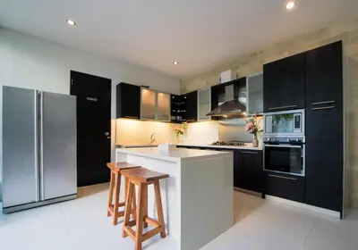 a kitchen with black cabinets and a white refrigerator at 7to8BR 40 off special Brilliant Location in Seminyak