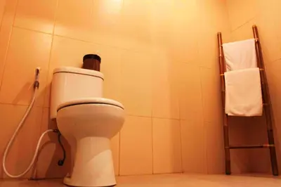 a bathroom with a white toilet in a room at Mansu Hotel and Spa Legian in Kuta