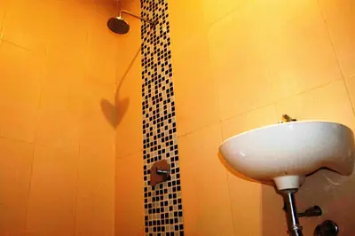 a bathroom with a sink and a black and white shower at Mansu Hotel and Spa Legian in Kuta