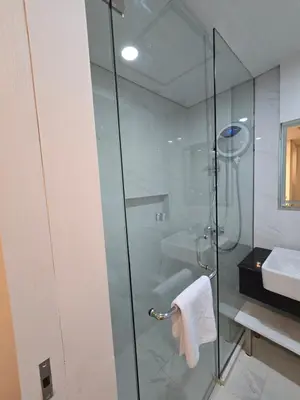 a bathroom with a glass shower and a sink at de' Asasta Apartment Benoa N508 in Nusa Dua