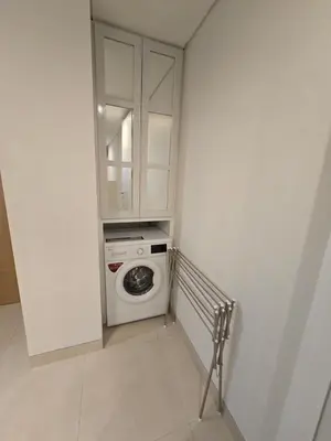 a small white laundry room with a washing machine at de' Asasta Apartment Benoa N508 in Nusa Dua