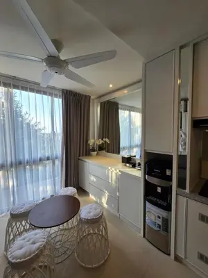 a kitchen with a table and some chairs and a ceiling fan at de' Asasta Apartment Benoa N508 in Nusa Dua