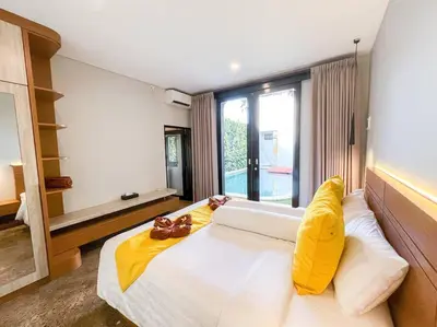 a bedroom with a large white bed with yellow pillows at Villa Raaadha 3BR modern design villa center of seminyak in Seminyak