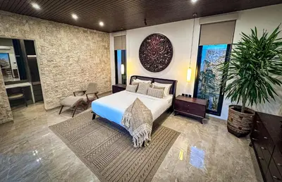 a bedroom with a bed and a potted plant at Nococu Luxury Villa in Seminyak