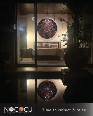 a room with a bed in a room with a mirror at Nococu Luxury Villa in Seminyak