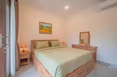 a bedroom with a large bed and a mirror at Titeng Guest House - Comfortable studio in amazing location near Potato Head and the beach in Seminyak
