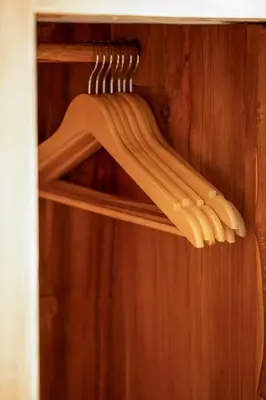 a group of wooden hangers on a wooden shelf at Titeng Guest House - Comfortable studio in amazing location near Potato Head and the beach in Seminyak