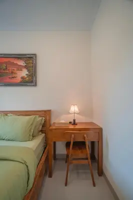 a bedroom with a bed and a desk with a lamp at Titeng Guest House - Comfortable studio in amazing location near Potato Head and the beach in Seminyak