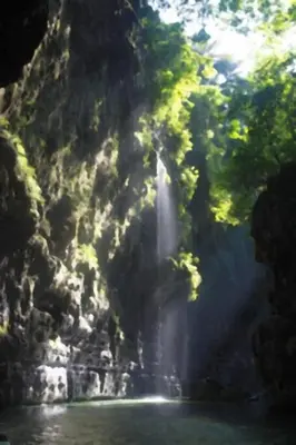 a waterfall in the middle of a river with trees at 20 off Special Brilliant Location in Seminyak
