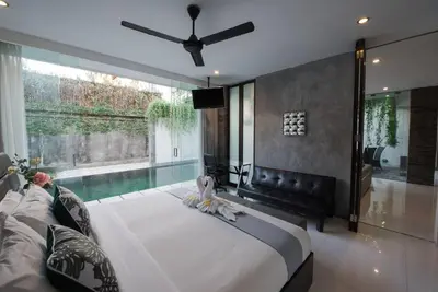 a bedroom with a large bed and a large window at 20 off Special Brilliant Location in Seminyak