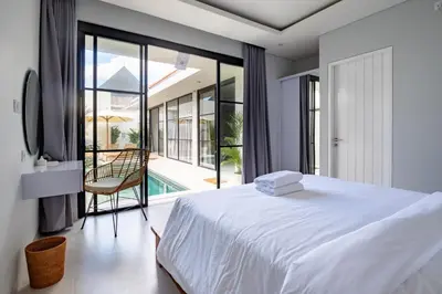a bedroom with a bed and a view of a pool at Letto 2 - Amazing 2BR Villa in Canggu with Private Pool in Canggu