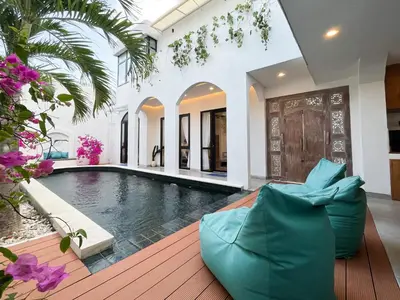 a swimming pool in a villa with a couch in a house at Villa Paros 3BR Greek Island Villa in Seminyak in Seminyak