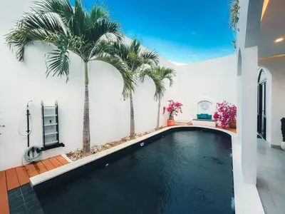 a swimming pool with palm trees in a house at Villa Paros 3BR Greek Island Villa in Seminyak in Seminyak