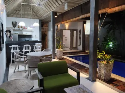 a living room with a pool and a table and chairs at JOJOBY sunset villa in Seminyak