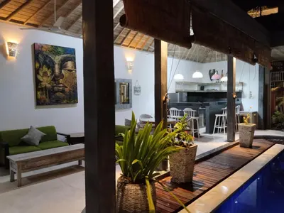 a living room with a swimming pool and a living room at JOJOBY sunset villa in Seminyak