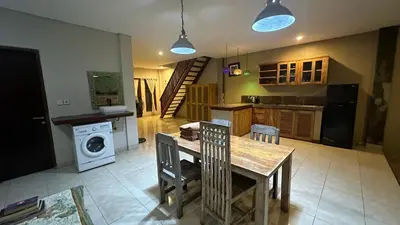 a kitchen with a table and chairs and a stove at Taman Giri House 3 Bedrooms Nusa Dua in Nusa Dua
