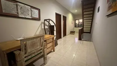 a hallway with a wooden desk and stairs in a house at Taman Giri House 3 Bedrooms Nusa Dua in Nusa Dua